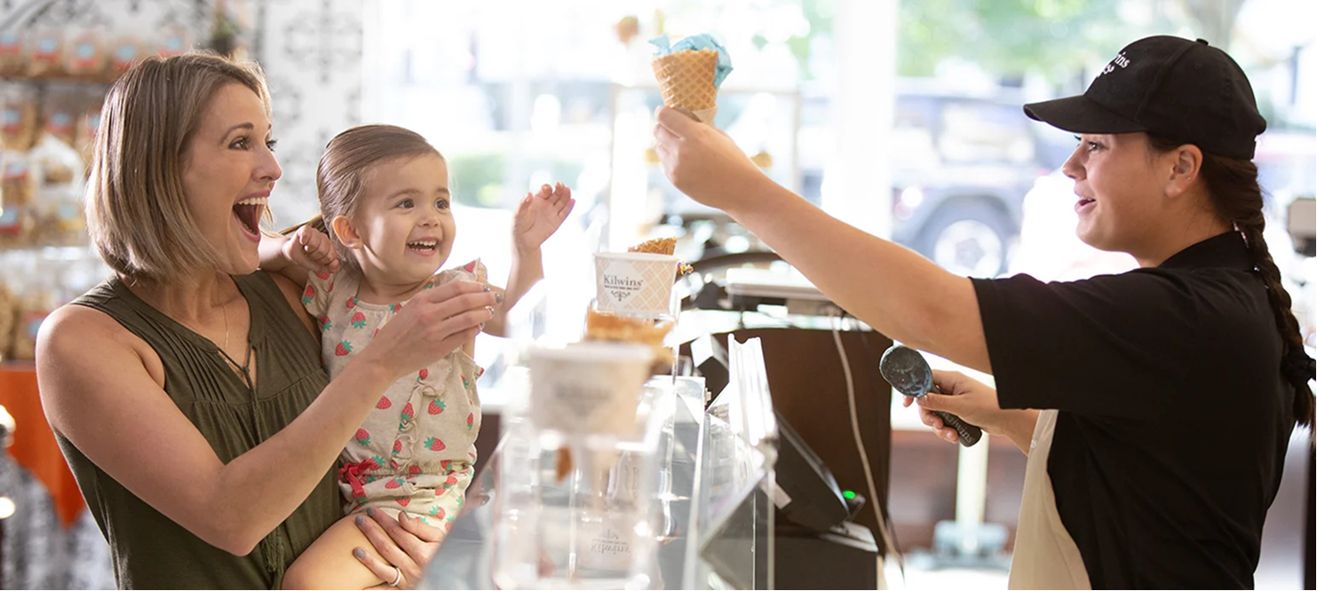 Mother and child receiving ice cream at shop