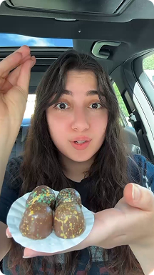 Woman holding dubai chocolate truffles in car